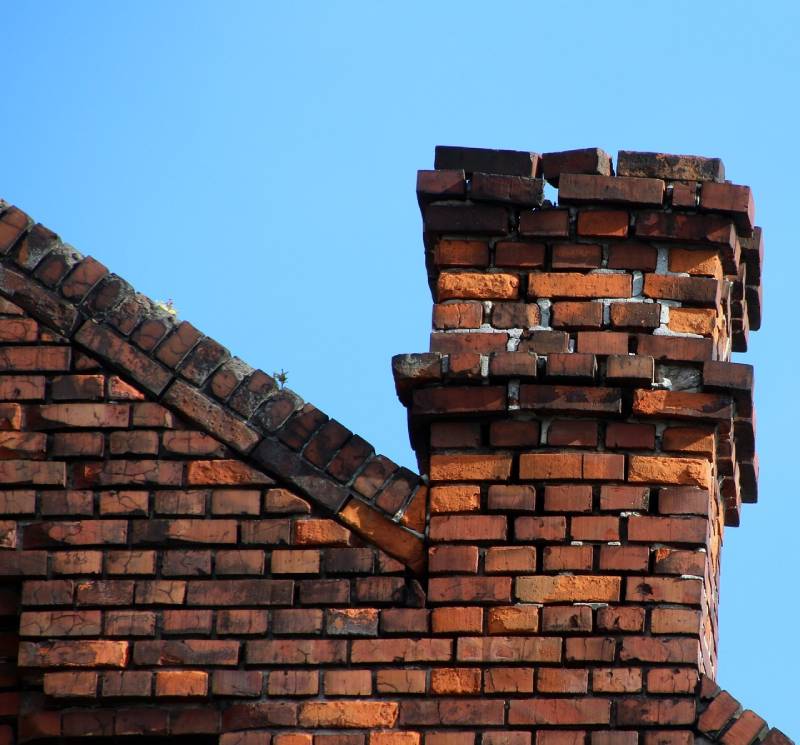 Damaged chimney on an Elkridge home showing cracks and missing mortar